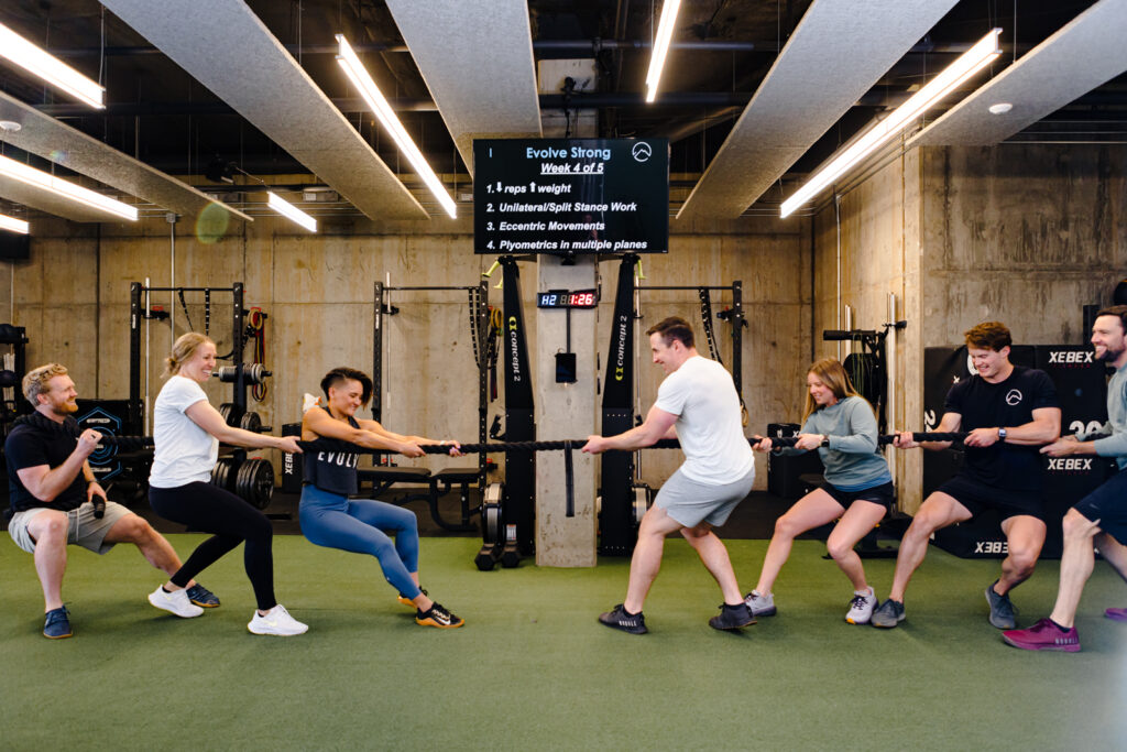 EVOLVE Flagstaff staff playing tug of war on indoor gym turf